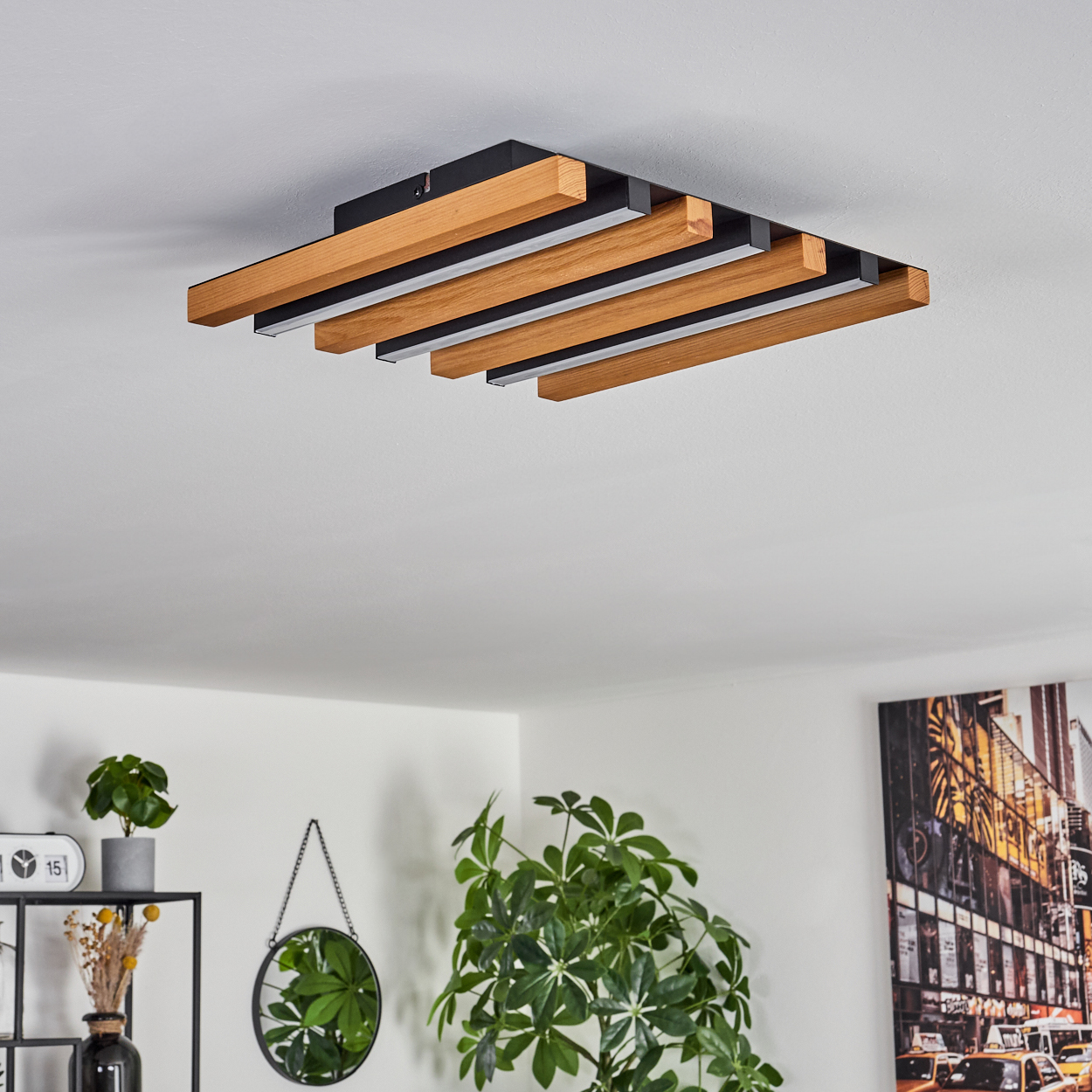 Moderne Deckenleuchte mit Holzlamellen und LED-Streifen über einem Wohnbereich.