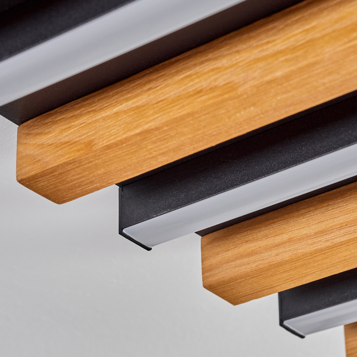Holz- und schwarze Balken mit integrierten Lichtern auf weißem Hintergrund.