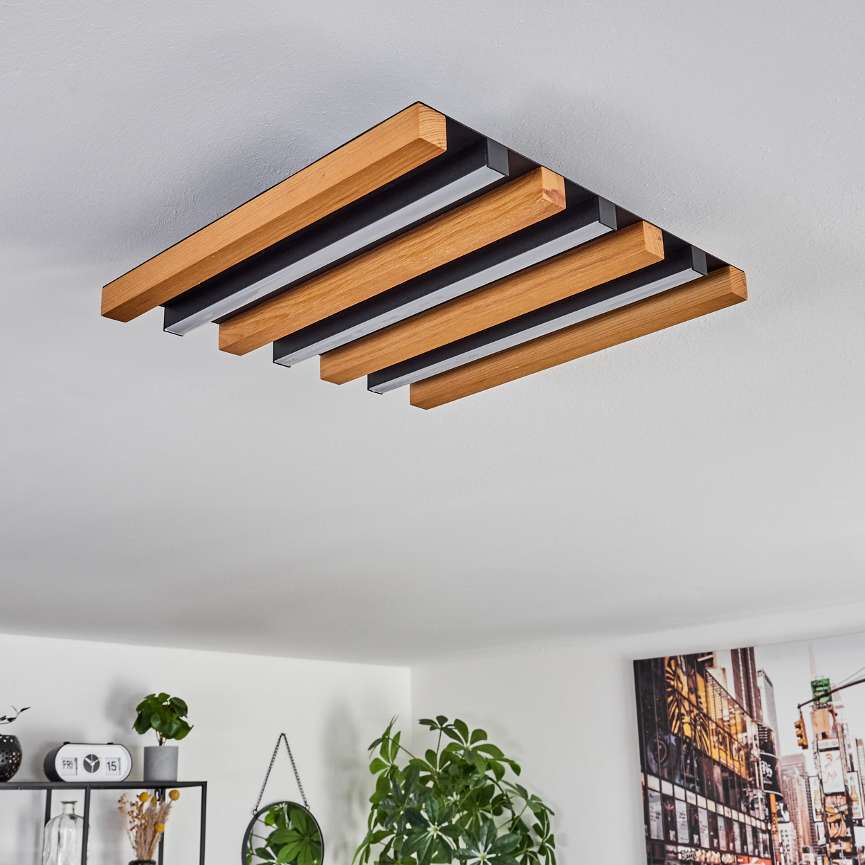 Eine Deckenleuchte mit Holz- und schwarzen Streifen hängt an einer weißen Decke.