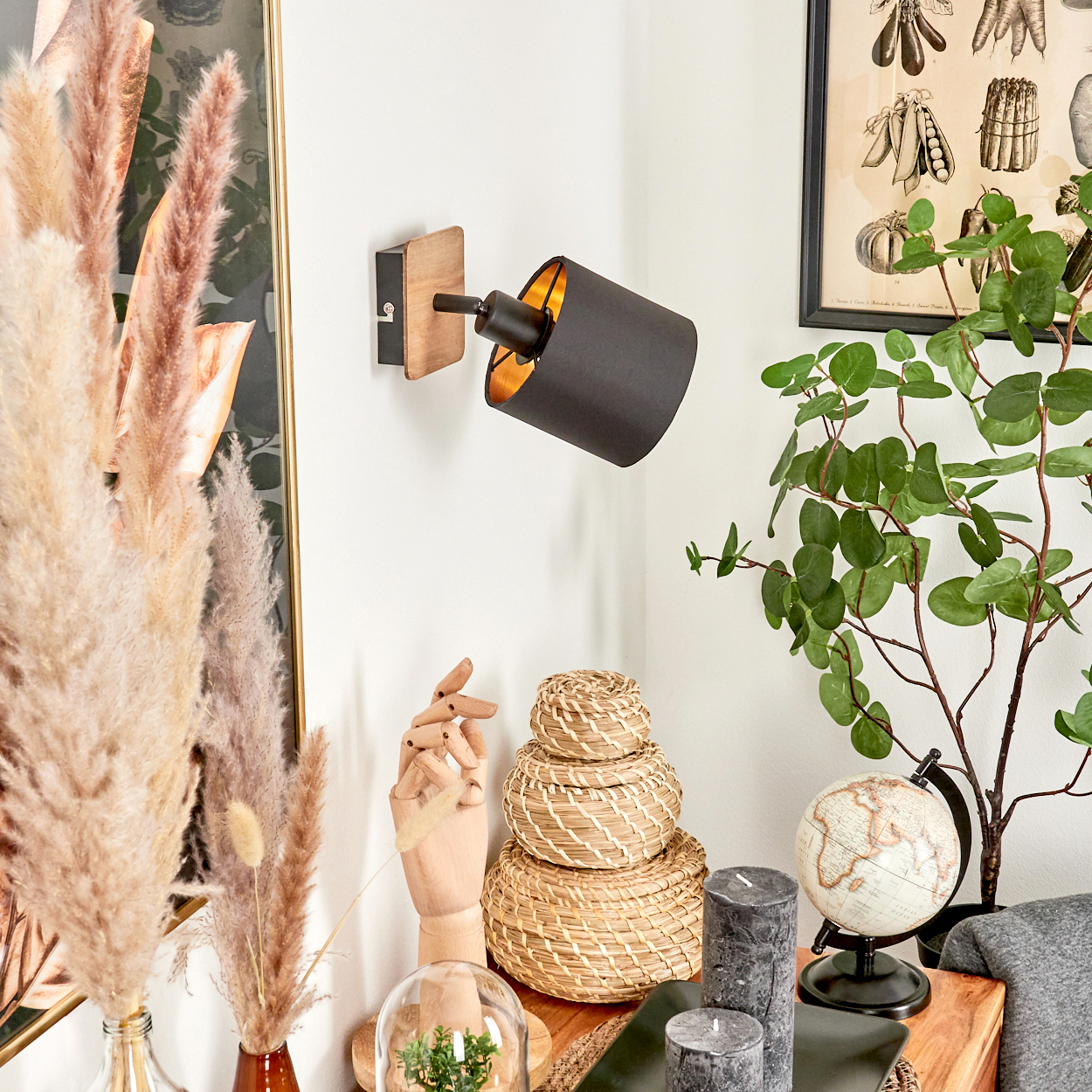 Ein Wandspot mit Holzbasis, schwarzem Schirm und goldenem Inneren.