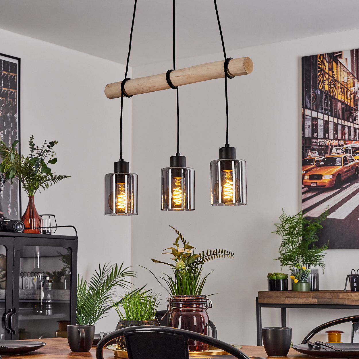 Hängeleuchte mit Holzstamm und drei Glaszylindern mit Glühbirnen.