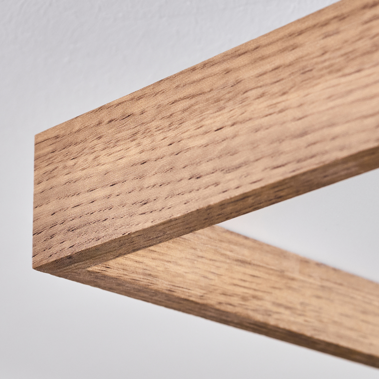 Nahaufnahme einer Holzstruktur mit Maserung auf weißem Hintergrund.