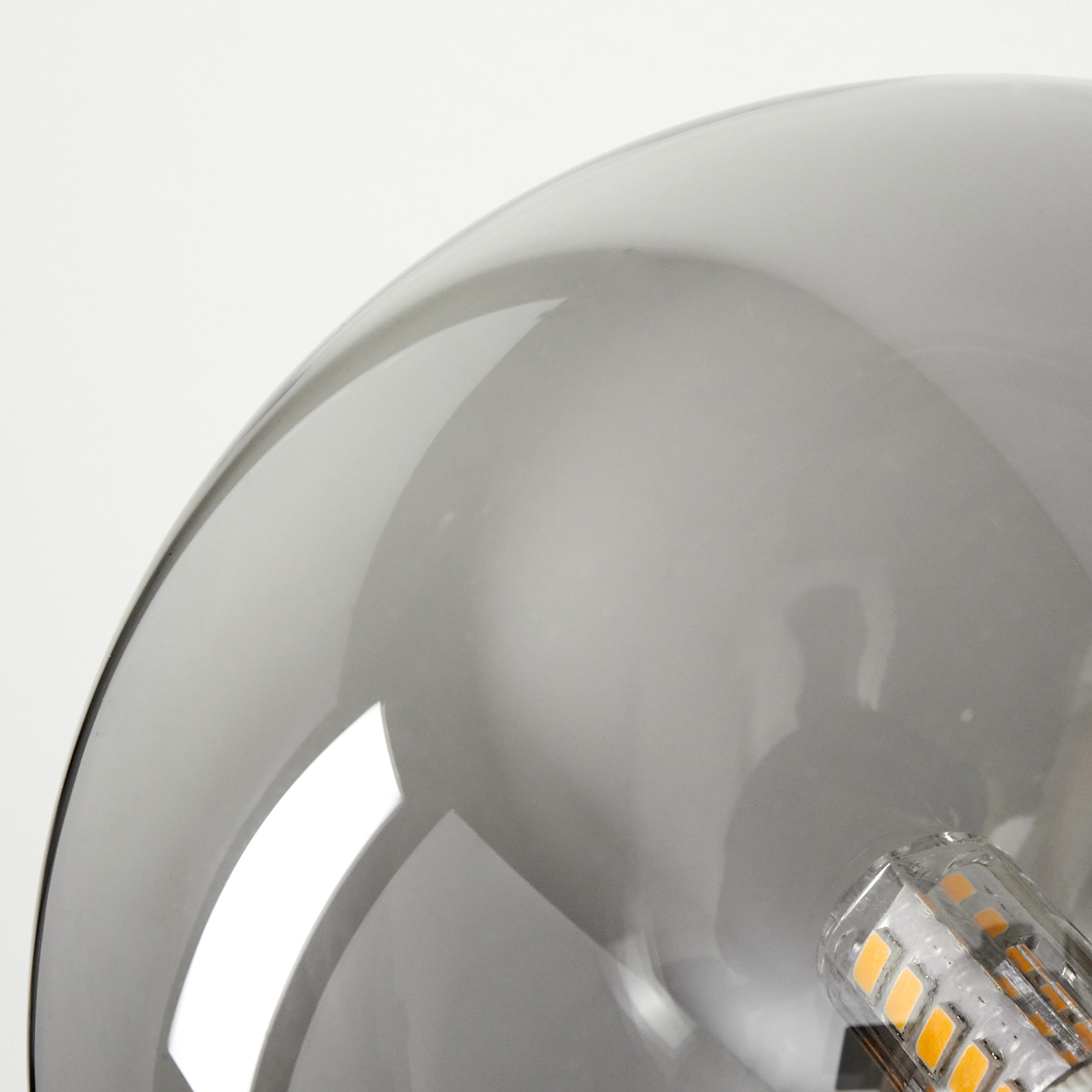 Grauer Rauchglas-Lampenschirm mit sichtbarem LED-Sockel und orangefarbenen Lichtern.