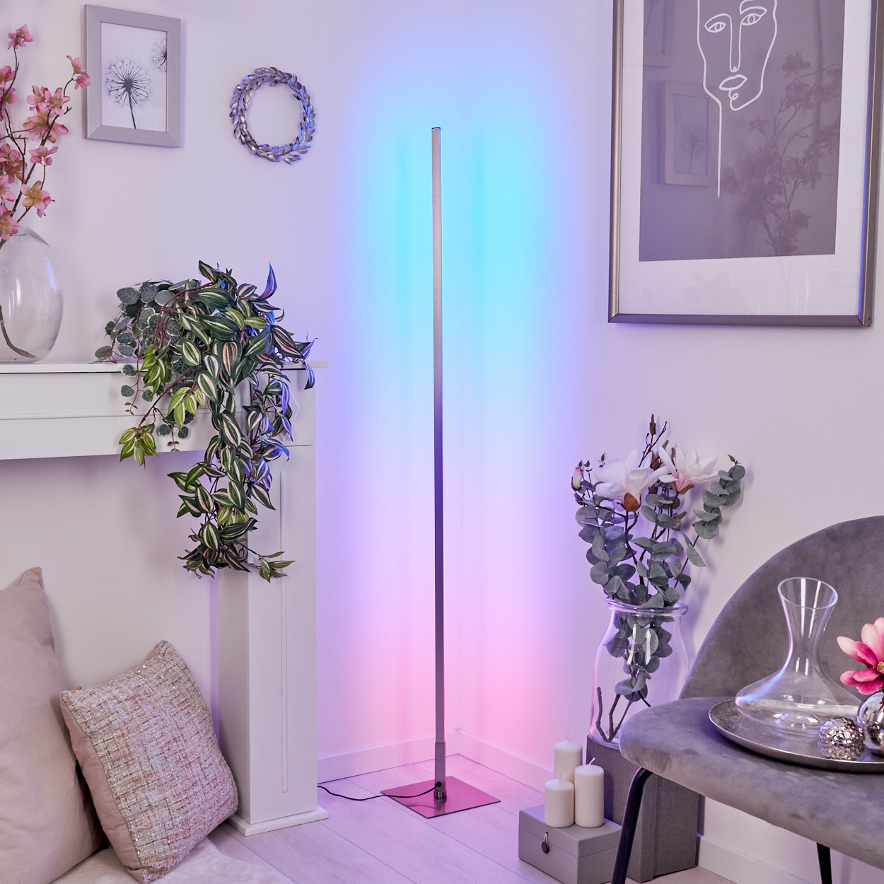 Ein moderner Stehlampe mit Farbwechsel beleuchtet einen Raum mit Kunst und Pflanzen.