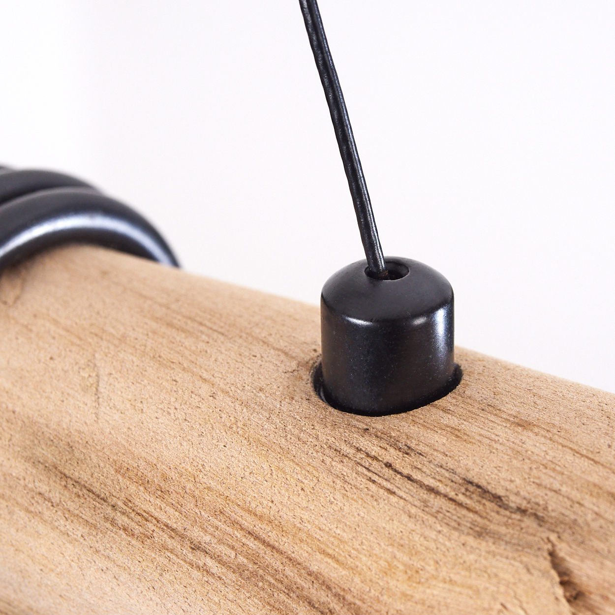Ein Holzbalken mit einem schwarzen Metallteil und Kabel.