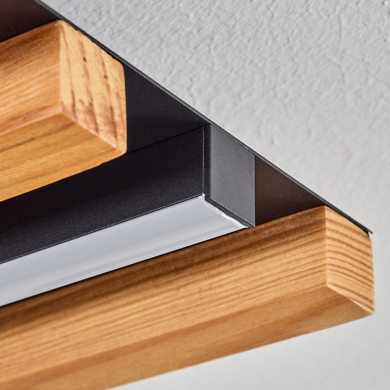 Holz- und schwarze Metallleuchte mit weißem Lichtstreifen, Nahaufnahme.