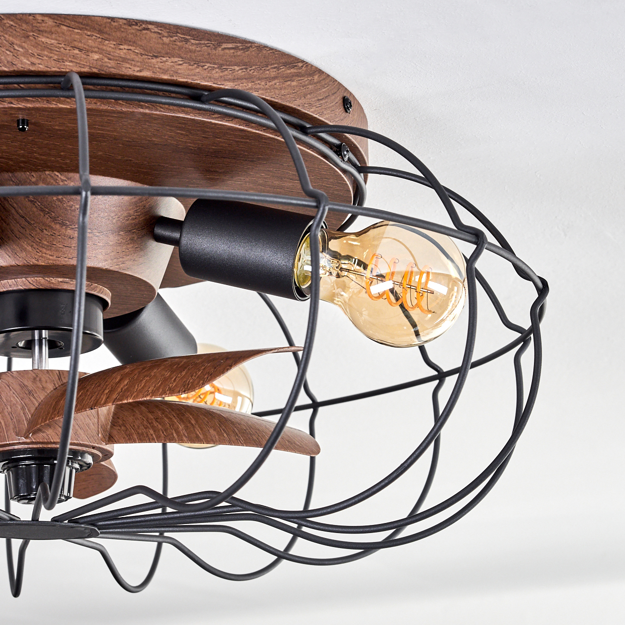 Deckenventilator mit Holzoptik, schwarzem Metallkäfig und Glühbirnen.