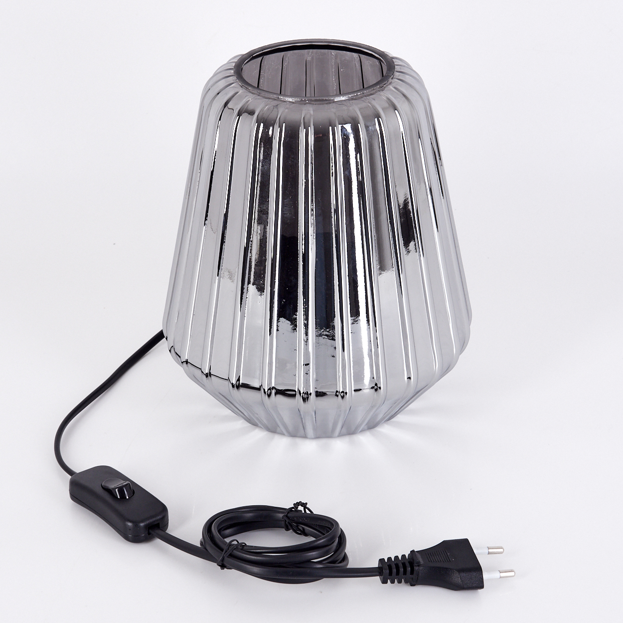 Silberne Lampe mit geripptem Glas und schwarzem Kabel mit Schalter und Stecker.