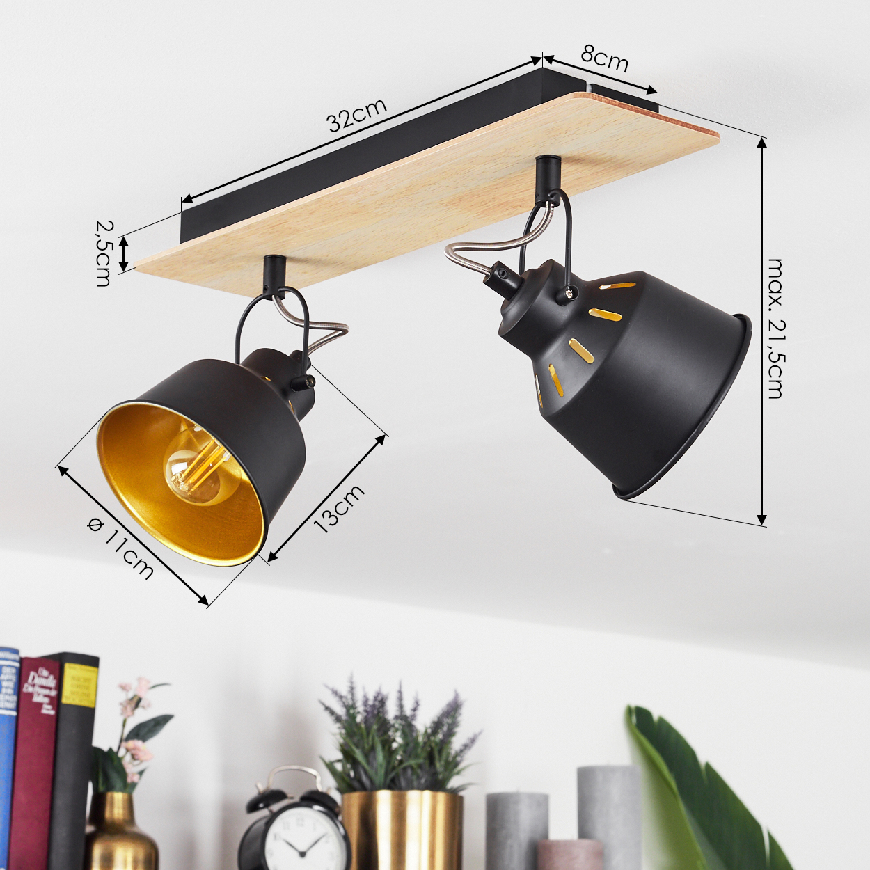 Zwei schwarze Lampen mit goldenen Innenseiten auf Holzsockel.