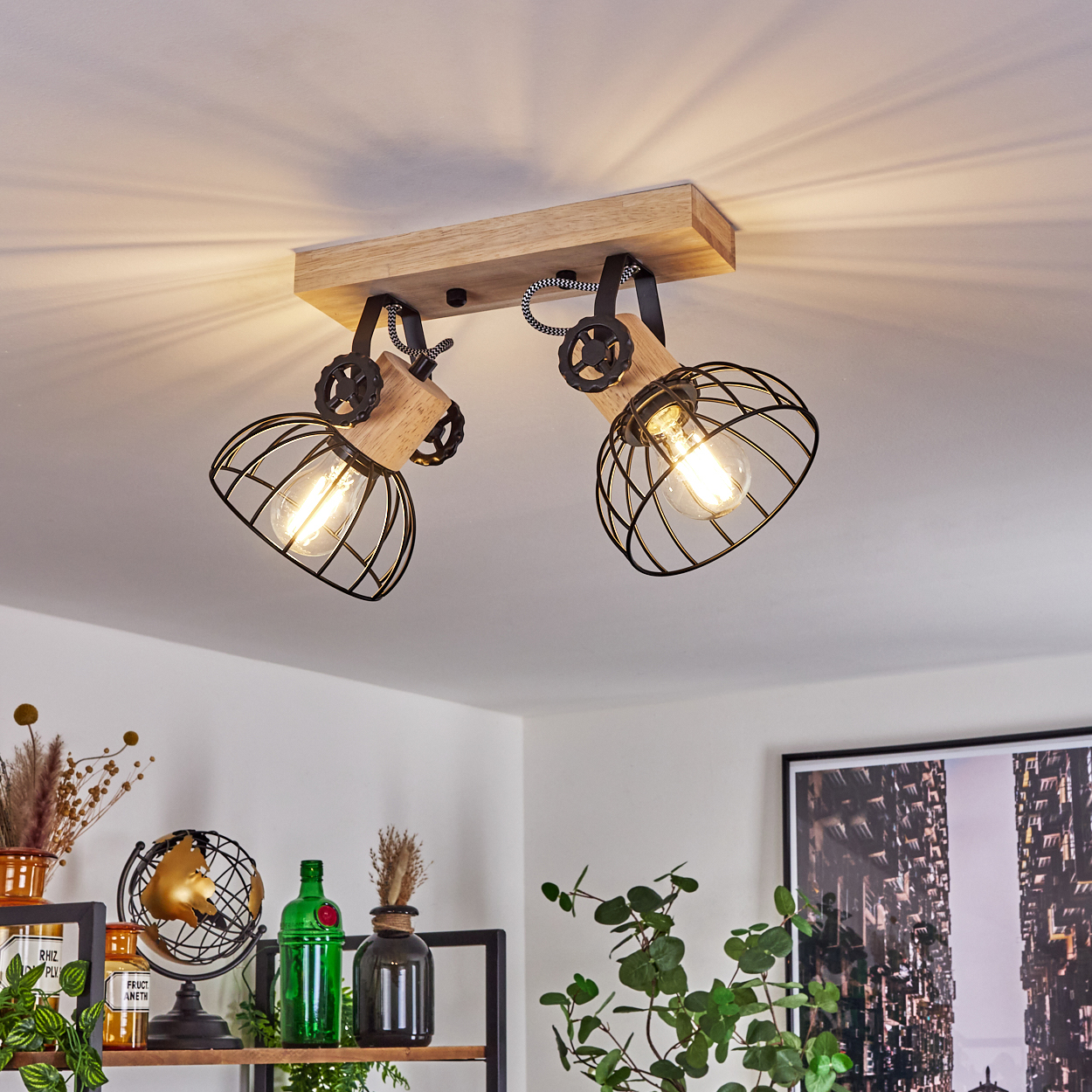 Eine Deckenleuchte aus Holz mit zwei schwarzen Metallkäfiglampenschirmen.