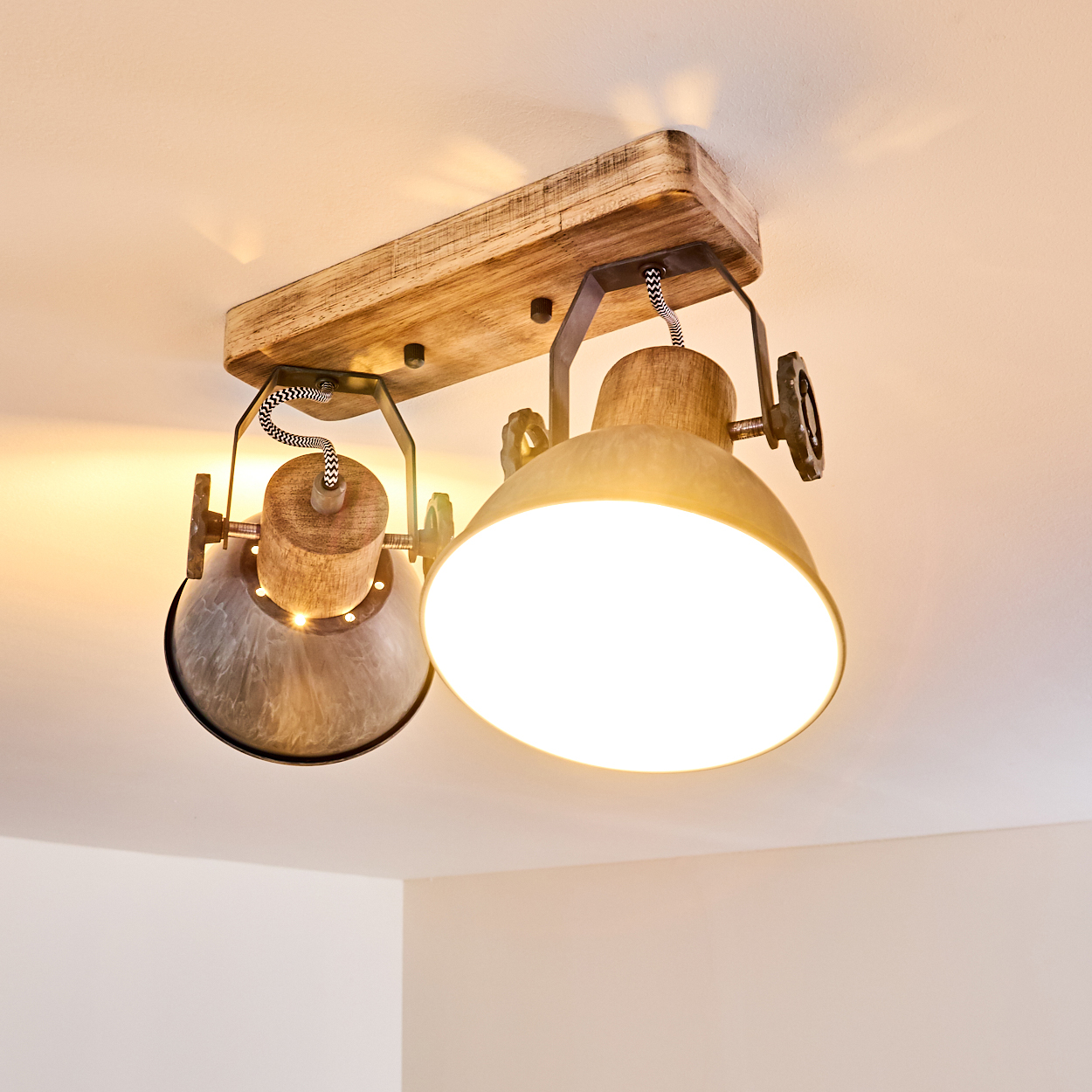 Eine Deckenleuchte mit zwei Lampenschirmen aus Metall und Holz.