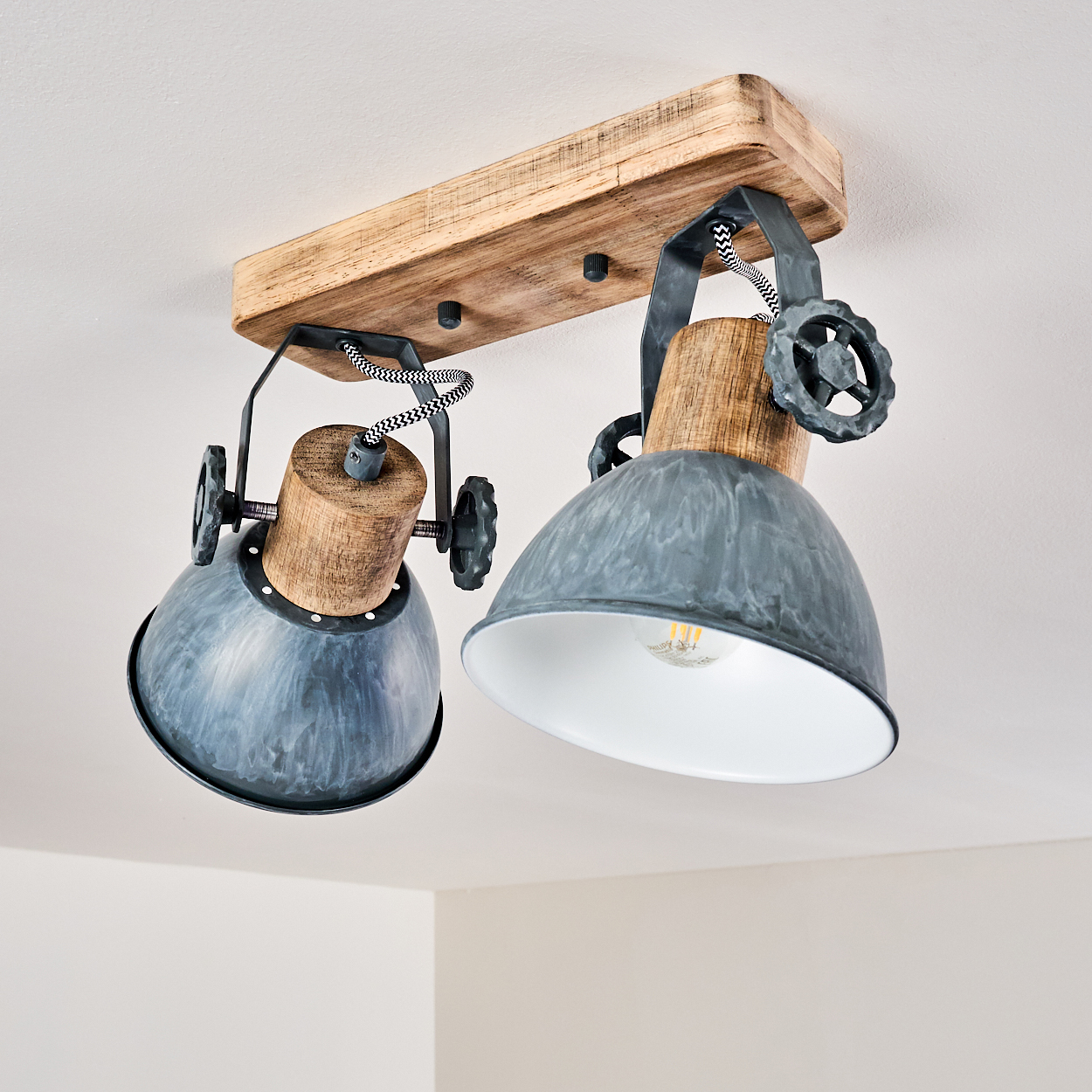 Eine Deckenleuchte mit Holzsockel, zwei grauen Metallschirmen und sichtbaren Glühbirnen.