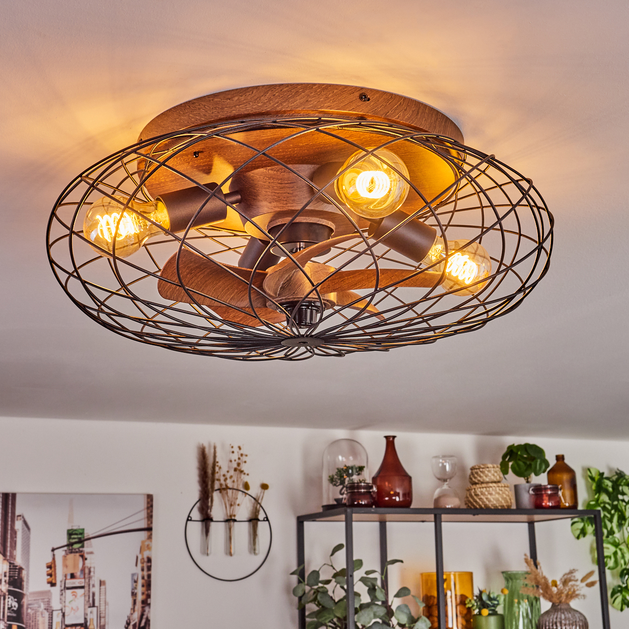 Deckenventilator mit Holzoberfläche und schwarzem Drahtkäfig, vier Glühbirnen.