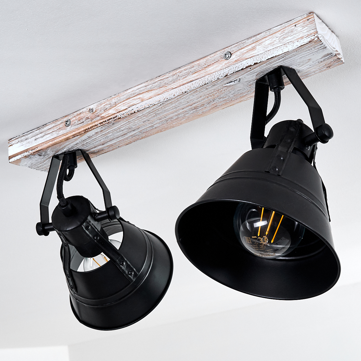 Zwei schwarze Lampen an einem Holzbalken, die an der Decke montiert sind.