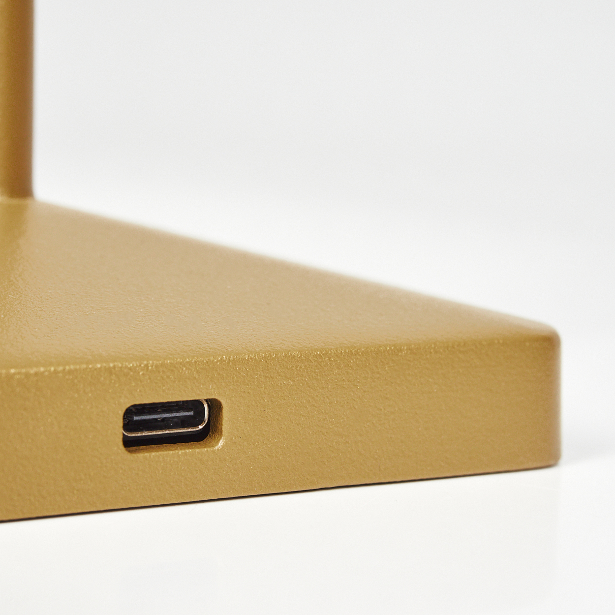 Eine goldene Basis mit einem USB-Anschluss auf weißem Hintergrund.