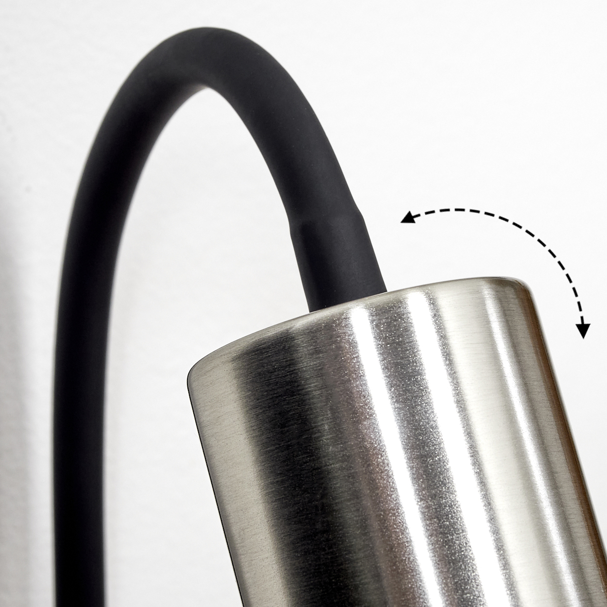Ein schwarzer Schlauch biegt sich über eine gebürstete Metalloberfläche.