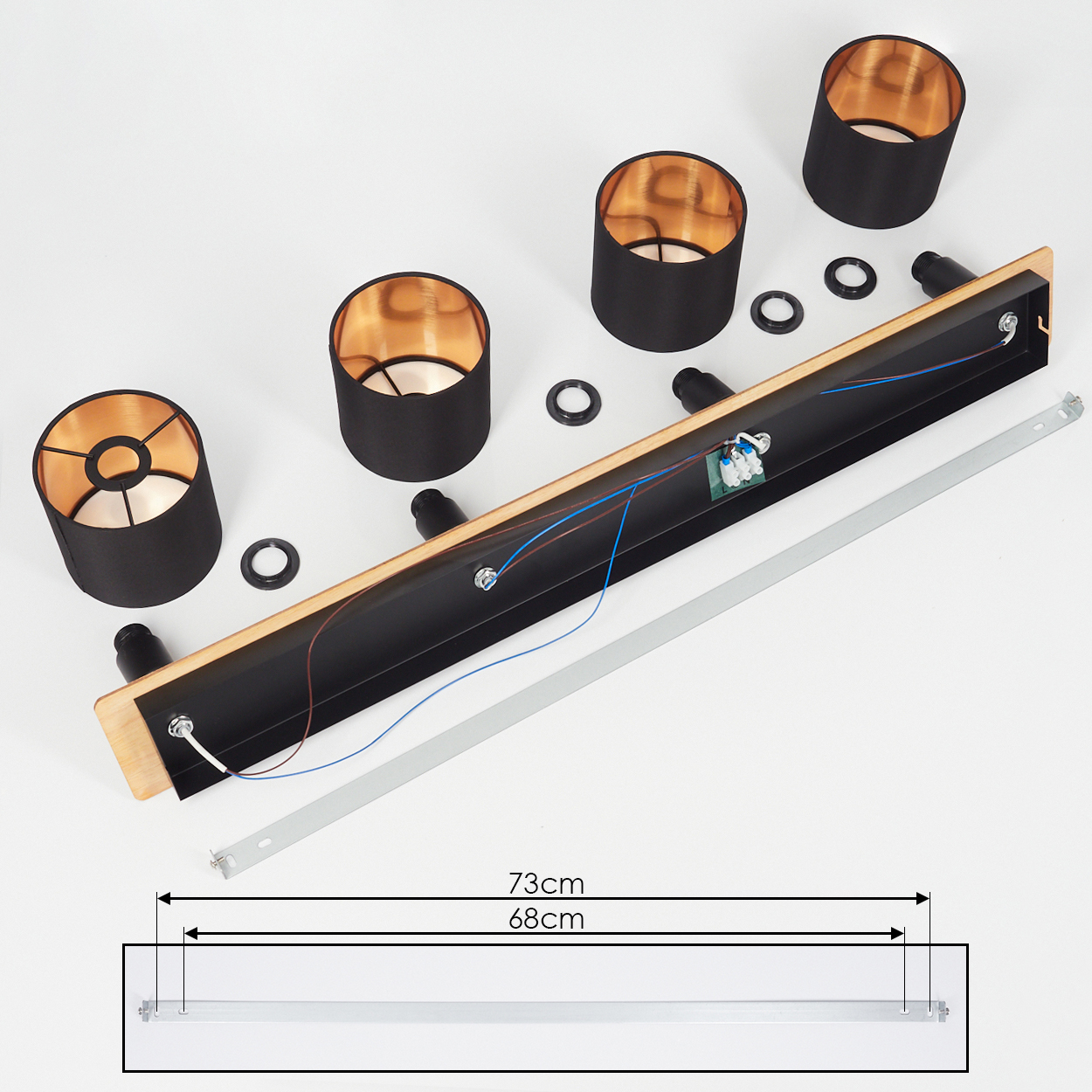 Ein Lampen-Kit mit schwarzen Schirmen, Kupferfutter, Holzbalken und Metallteilen.