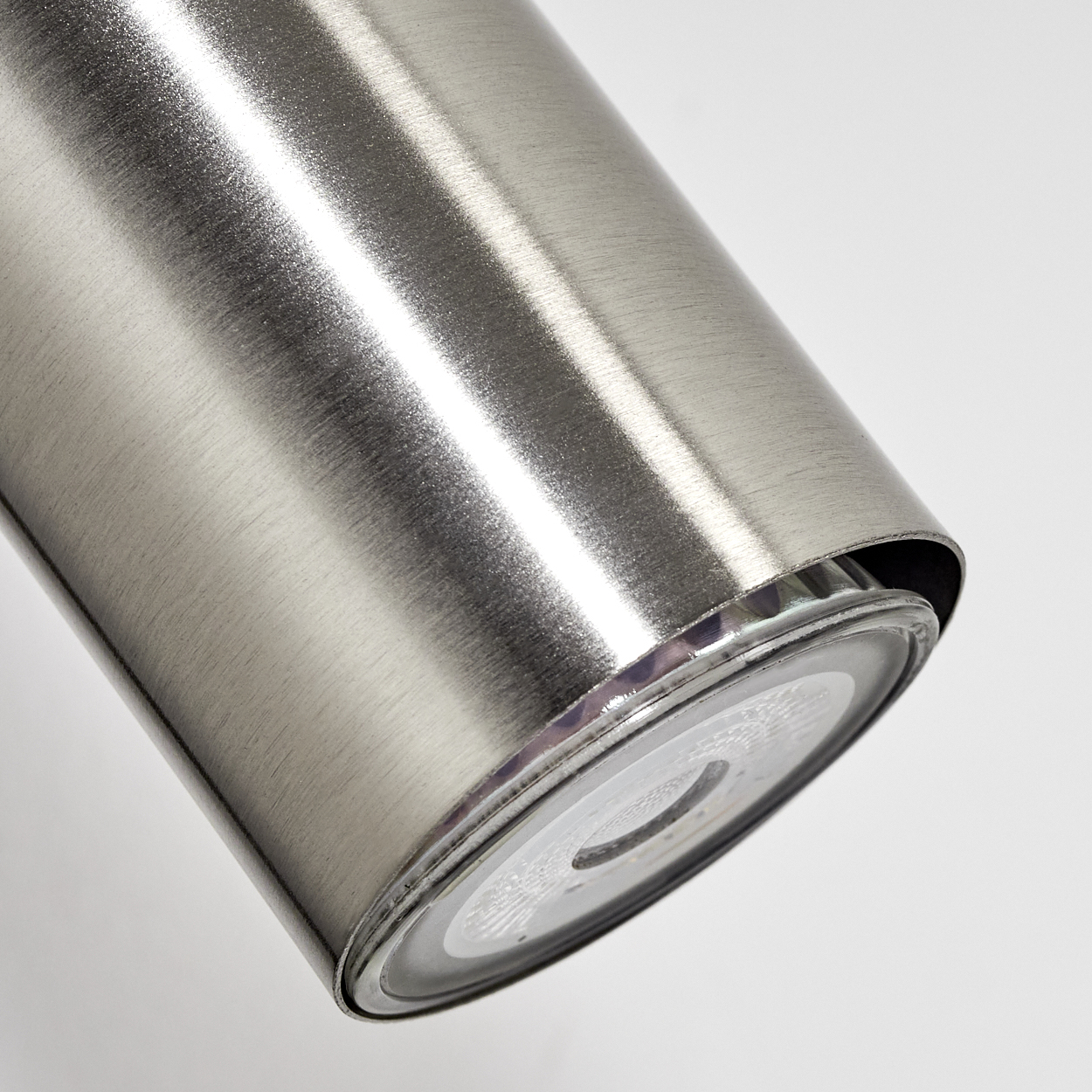 Nahaufnahme des unteren Teils eines silbernen Thermosbehälters mit gebürsteter Metalloberfläche.