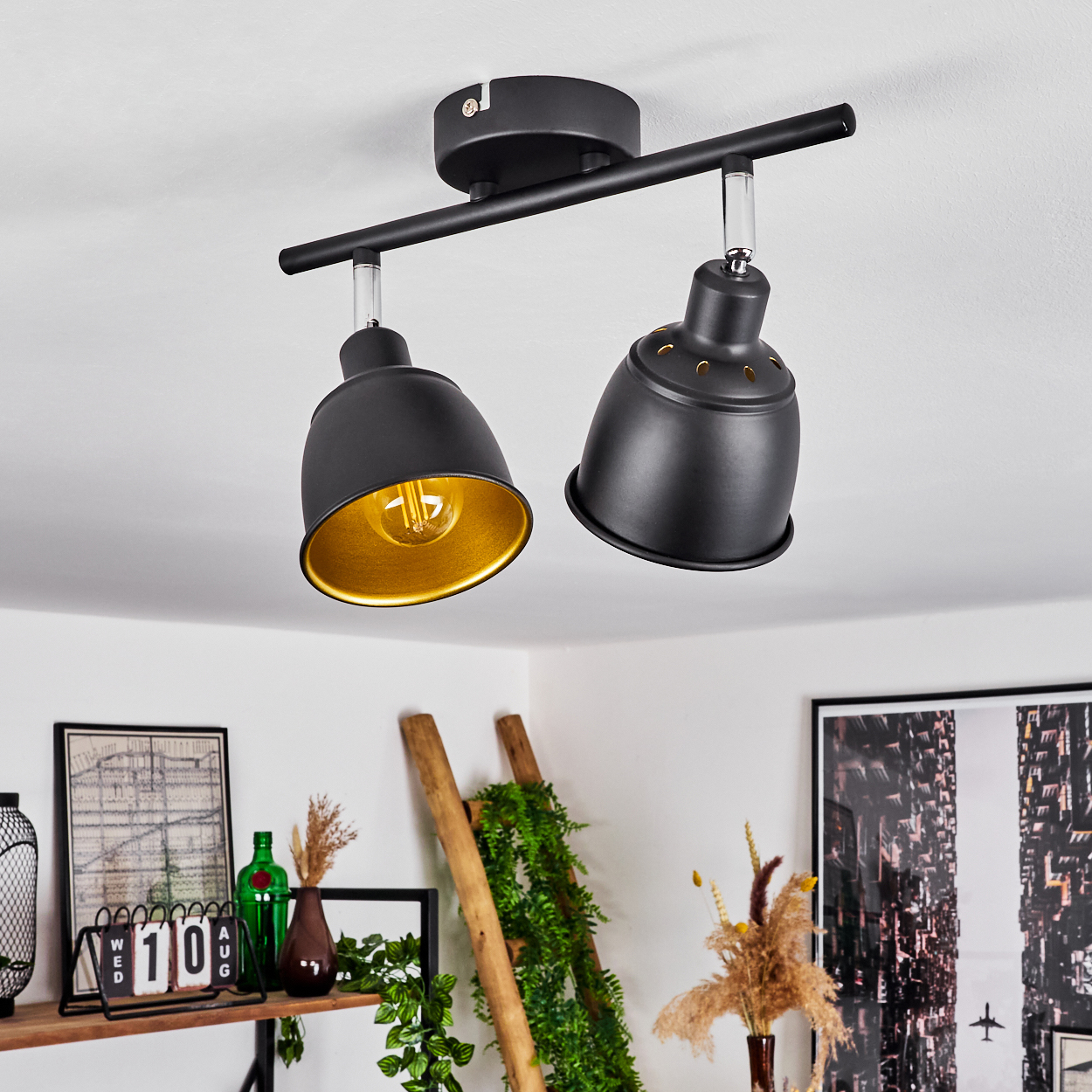 Schwarzer Deckenstrahler mit zwei verstellbaren Lampen und goldener Innenseite.