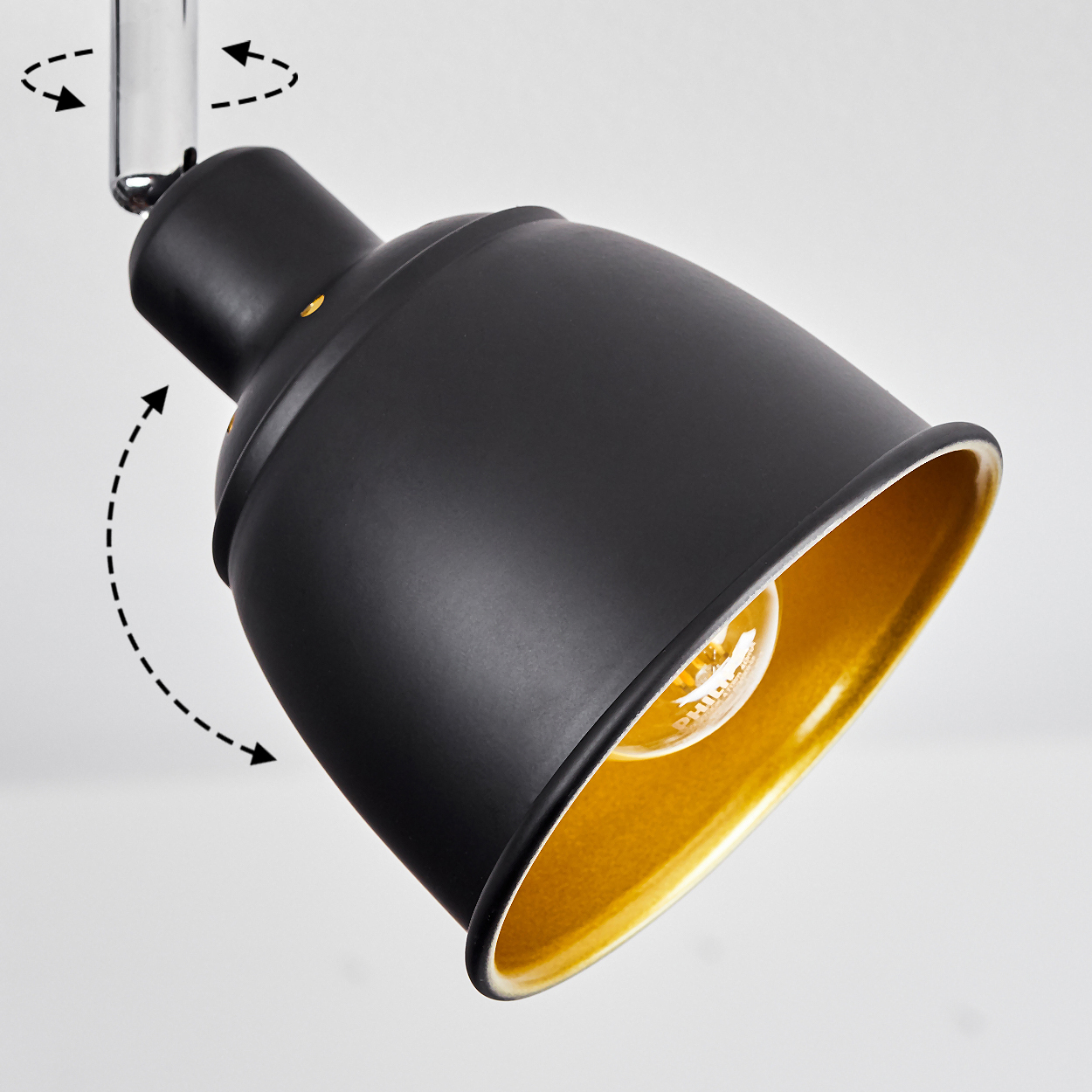 Eine schwarze Lampe mit goldener Innenseite, die sich drehen lässt.
