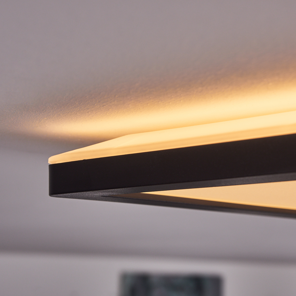 Ein moderner schwarzer Deckenleuchter mit warmweißem Licht.