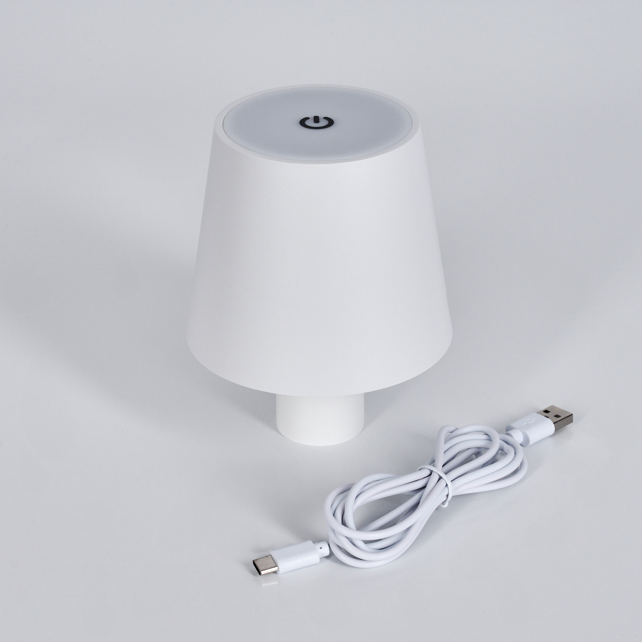 Eine weiße Lampe mit einem USB-C-Kabel auf weißem Hintergrund.