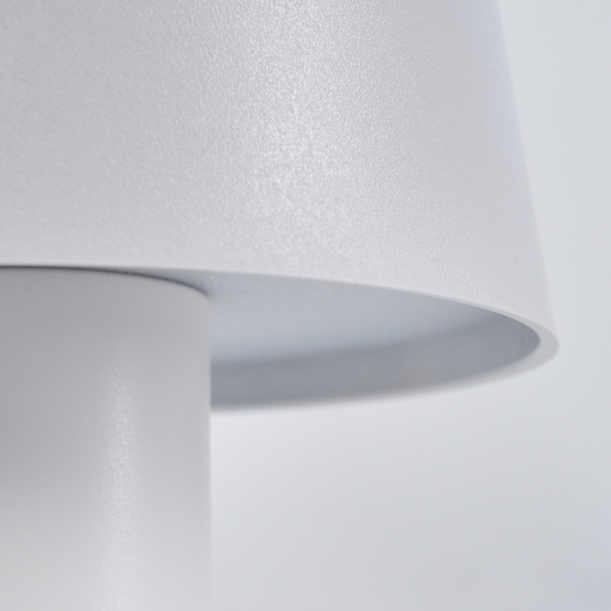 Nahaufnahme einer weißen Lampe mit glatter, matter Oberfläche und einem schmalen Rand.