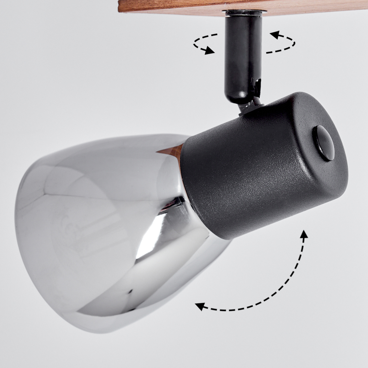 Schwenkbarer Lampenkopf aus Chrom mit schwarzem Gehäuse an Holzbasis.