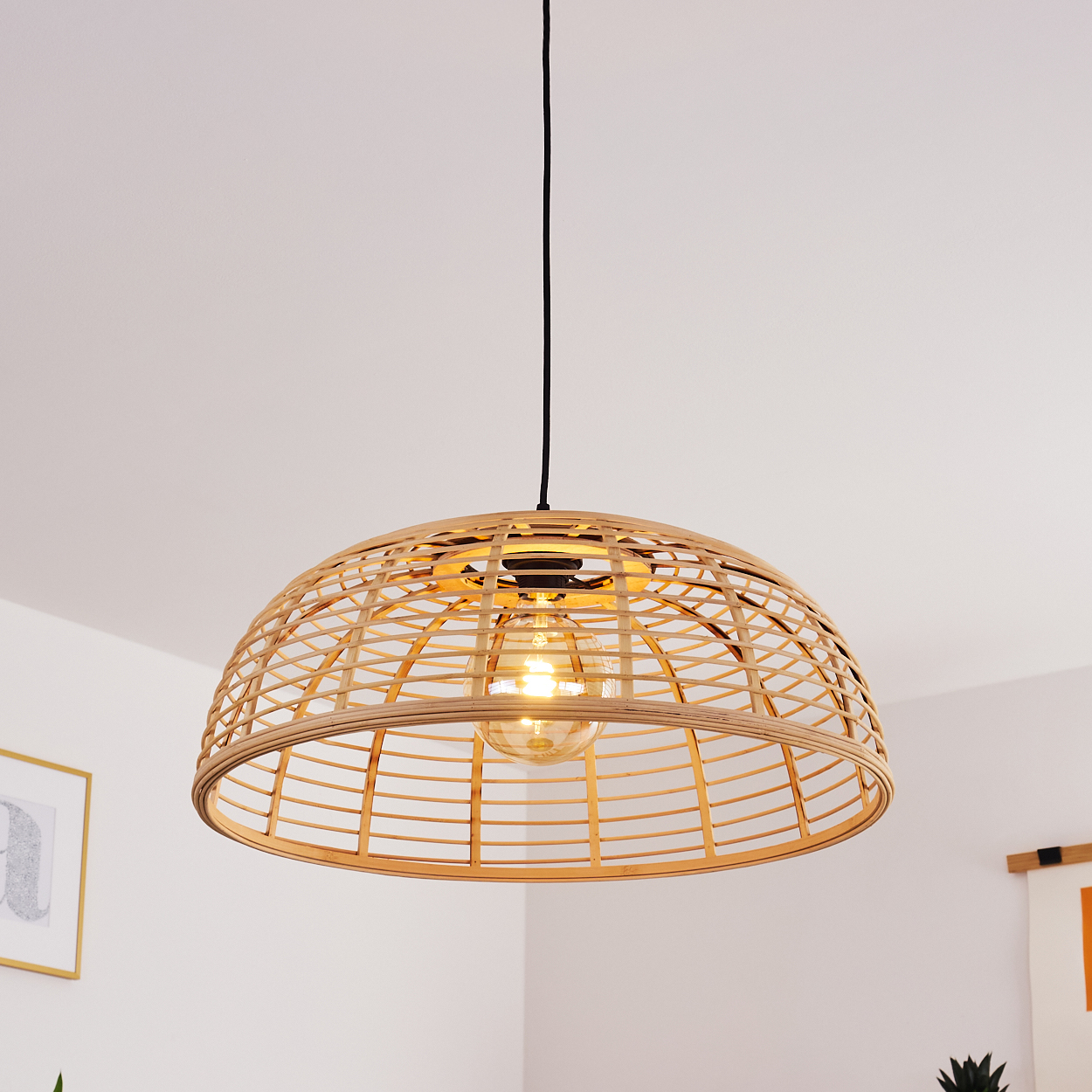Eine hängende Lampe aus geflochtenem Holz mit einer Glühbirne.