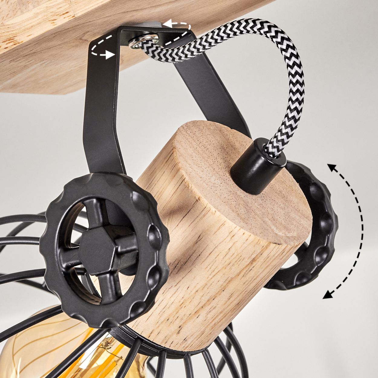 Holzdetails mit schwarzen Metallrädern und Kabel an einer Deckenleuchte.