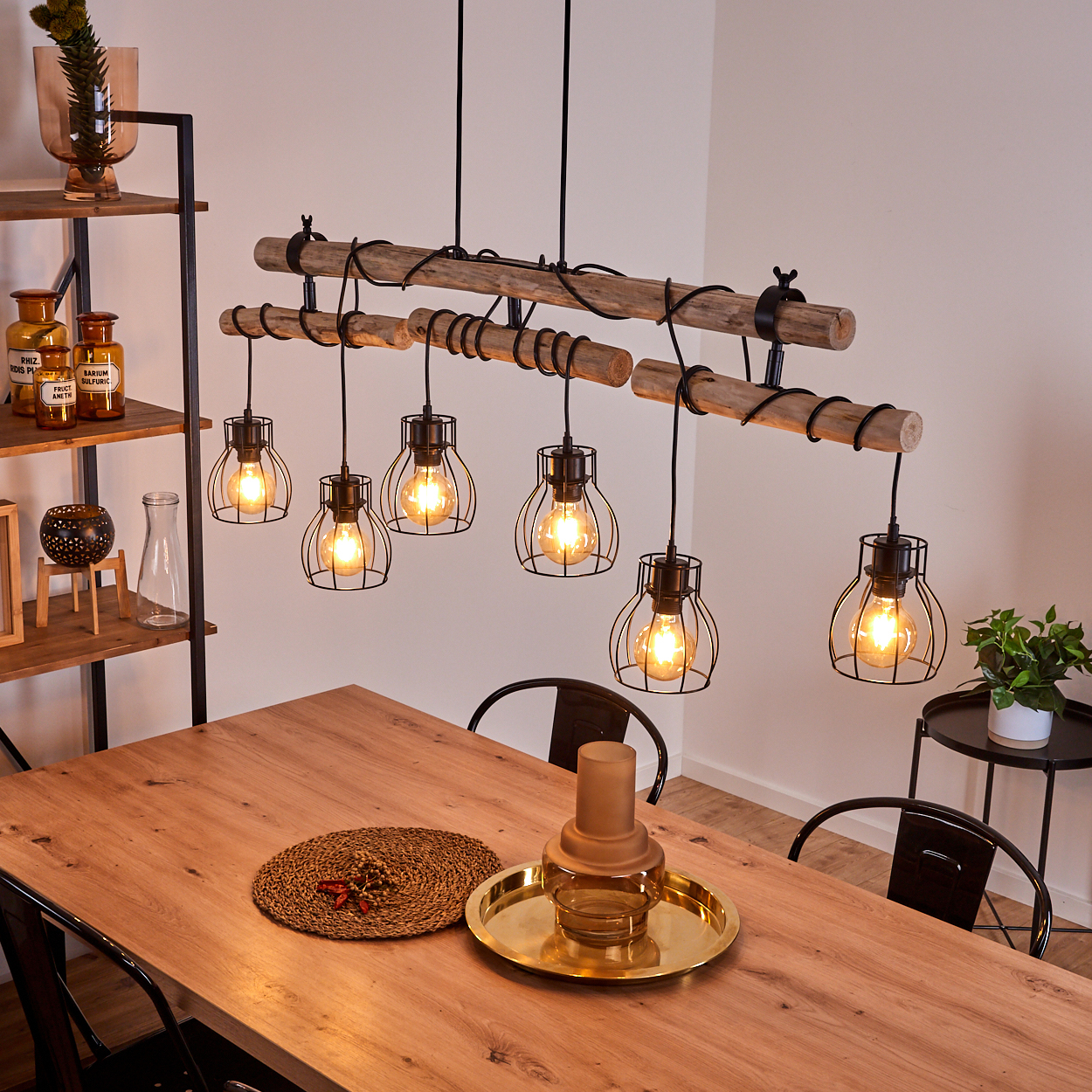Hängelampe aus Holz mit sechs Glühbirnen über einem Holztisch mit Deko.