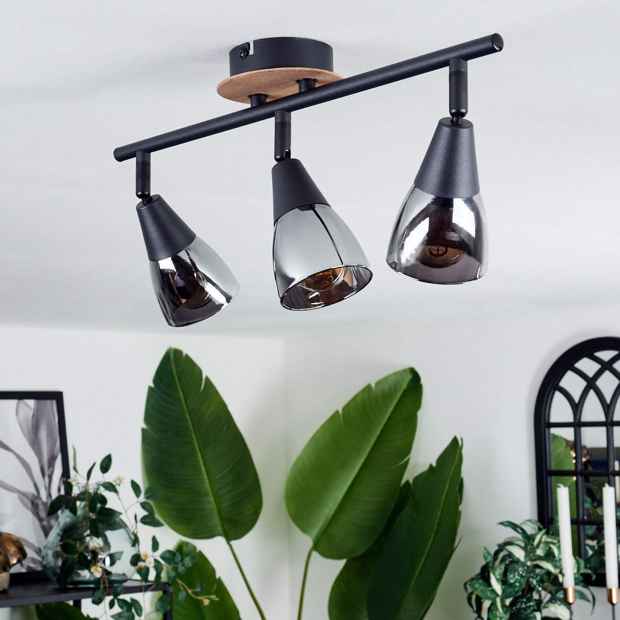 Deckenleuchte mit drei schwarzen, schwenkbaren Spotköpfen und Glasdiffusoren.