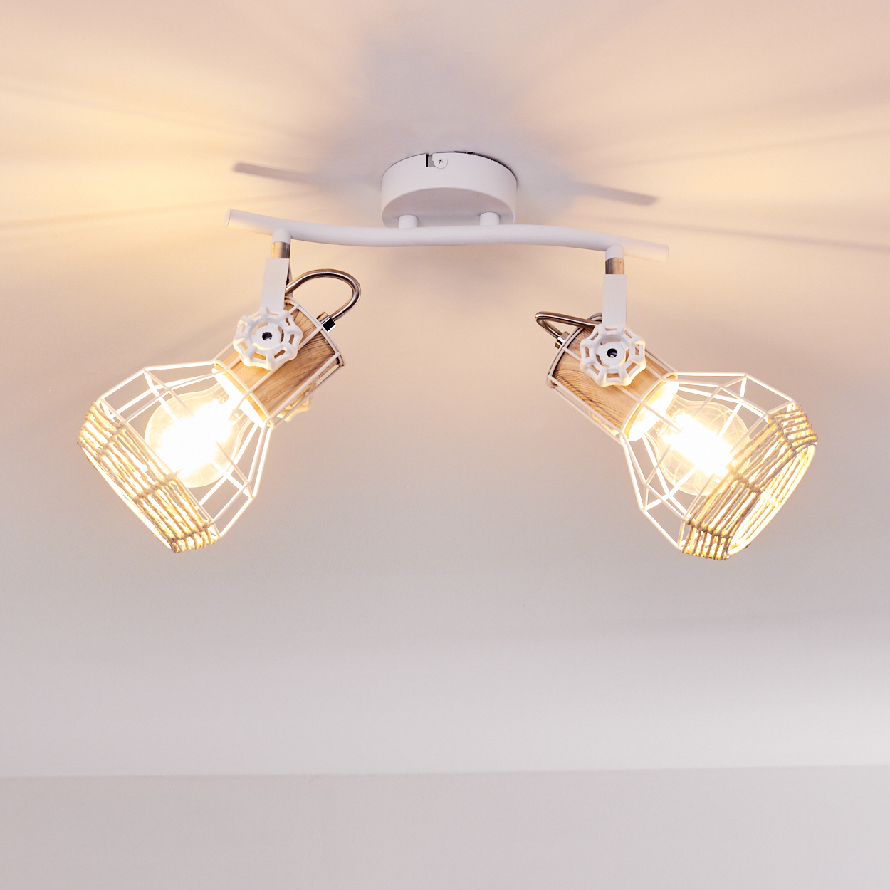 Zwei gerichtete Lampen mit weißem Metallkäfig und Holzdetails leuchten an der Decke.