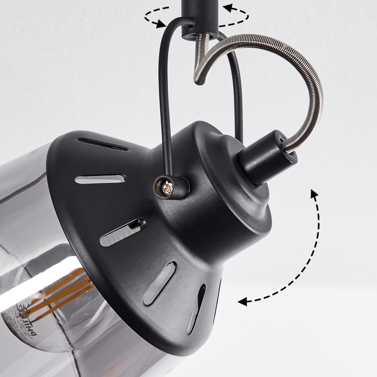 Eine schwarze Lampe mit Glaszylinder und sichtbarer Glühbirne, Gelenkmechanismus.