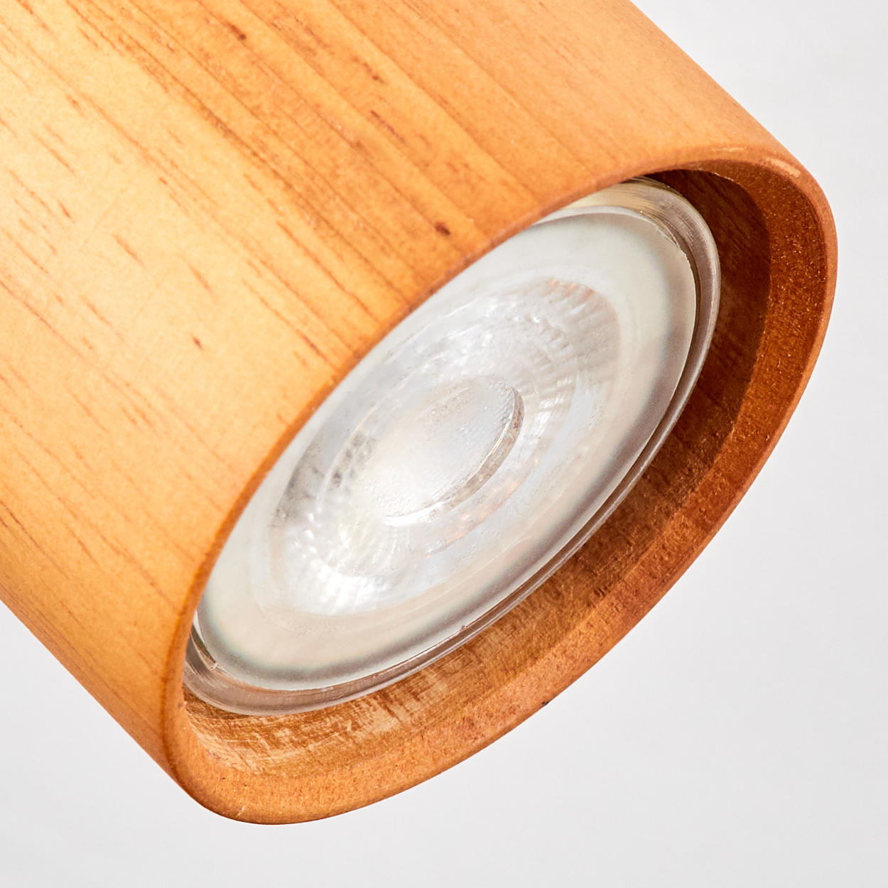 Nahaufnahme einer Holzlampe mit Glasabdeckung und sichtbarem Leuchtmittel.