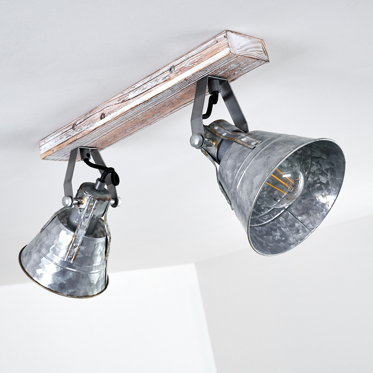 Eine Deckenleuchte mit zwei grauen Metallschirmen an einem Holzbalken.