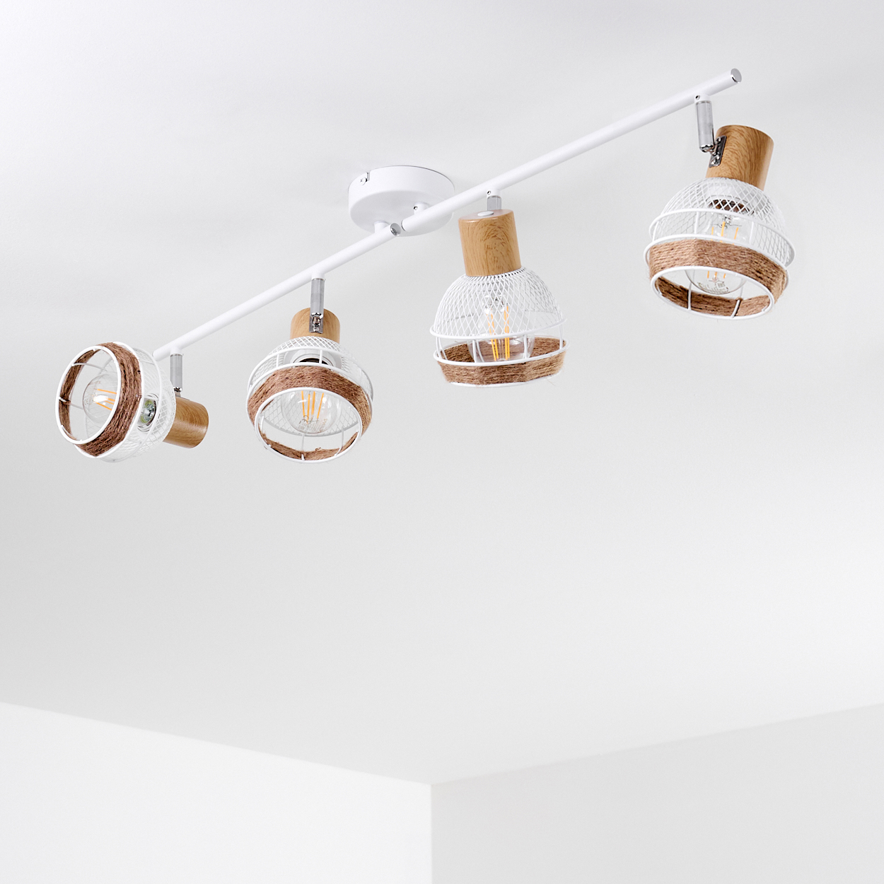 Eine weiße Schienenleuchte mit vier Pendelleuchten, jede mit einem Holzakzent und einem weißen Metallkäfig.