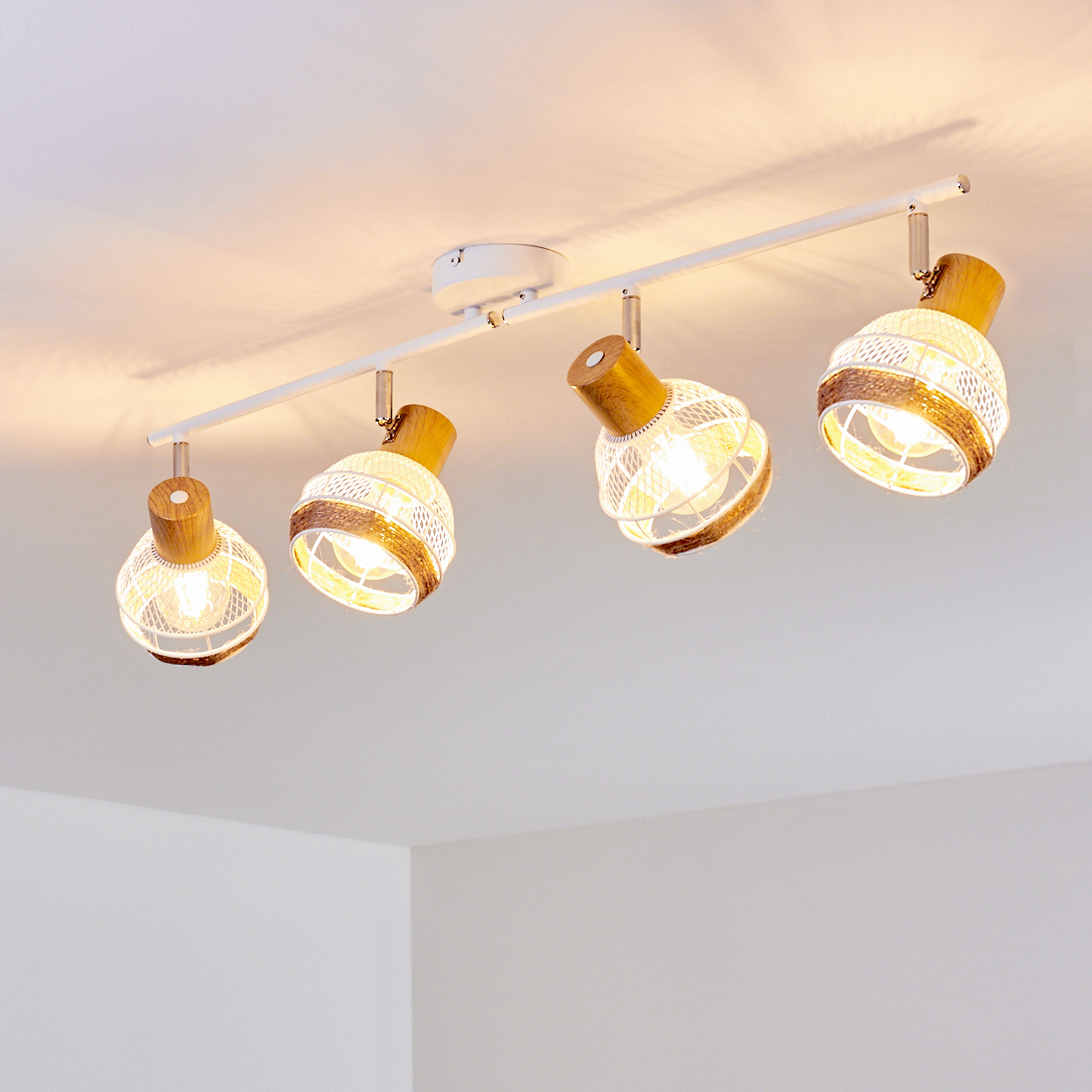 Vier Pendelleuchten mit Holzdetails und Drahtgeflecht auf einer weißen Schiene.