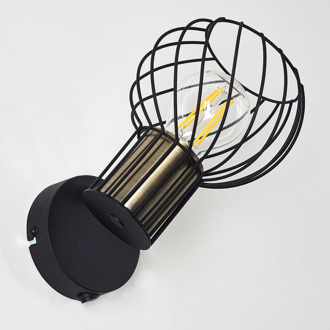 Schwarze Wandleuchte mit Metallkäfig und sichtbarer Edison-Glühbirne.