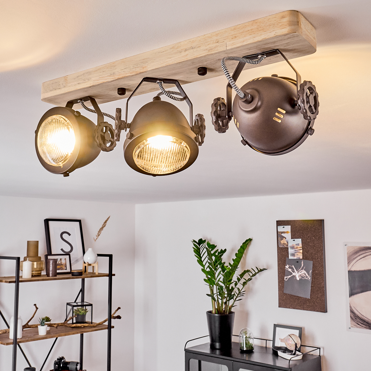 Ein Deckenstrahler mit drei Lampen auf einem Holzbrett, im Stil eines Industrie-Designs.