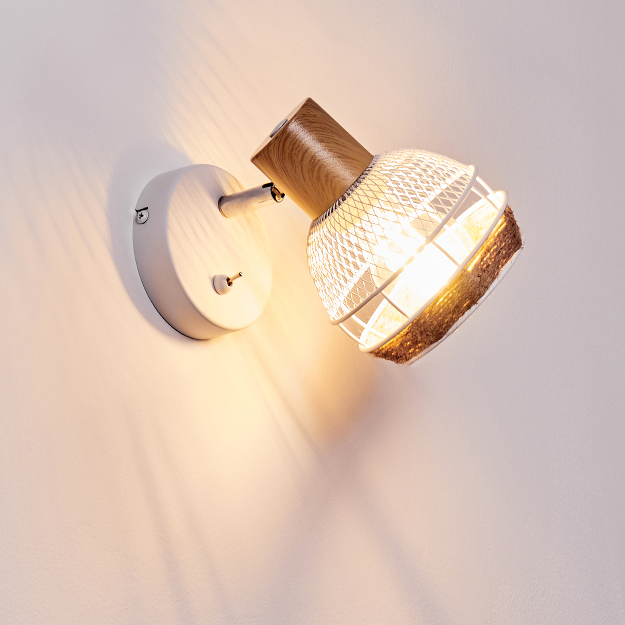 Eine Wandleuchte mit Holzakzent und weißem Metallschirm beleuchtet die Wand.