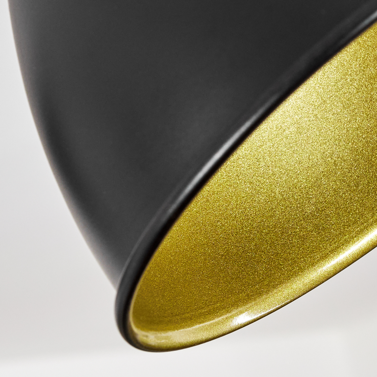 Nahaufnahme einer schwarzen Lampe mit glänzend goldenem Innenraum auf weißem Hintergrund.