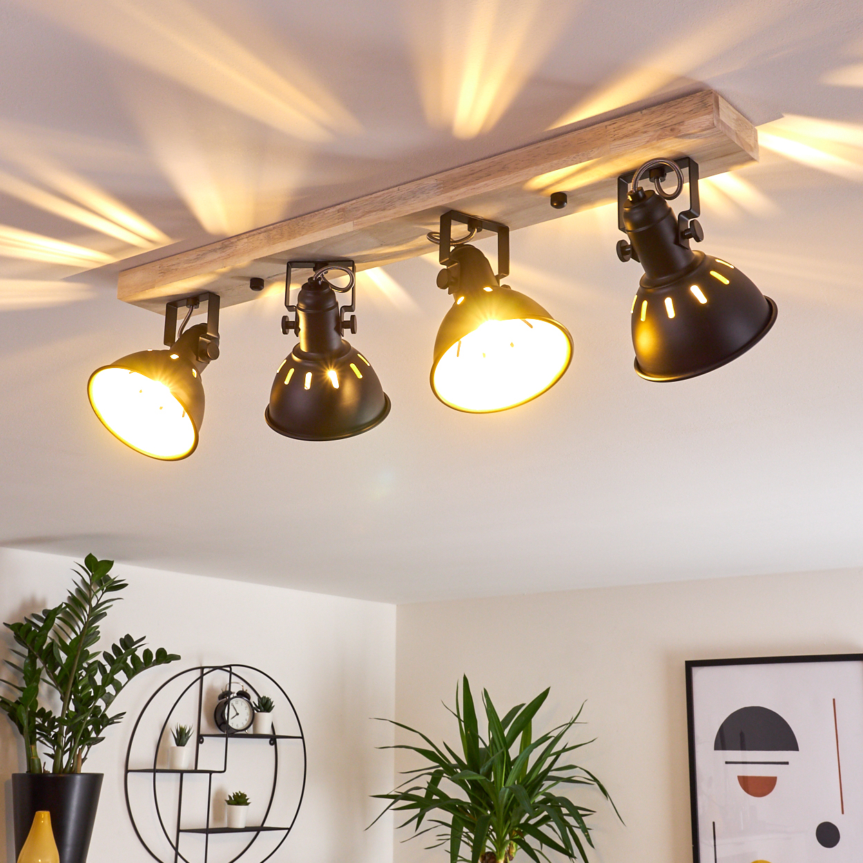 Holzdeckenleuchte mit vier schwarzen Lampenschirmen und Lichtstrahlen an der Decke.