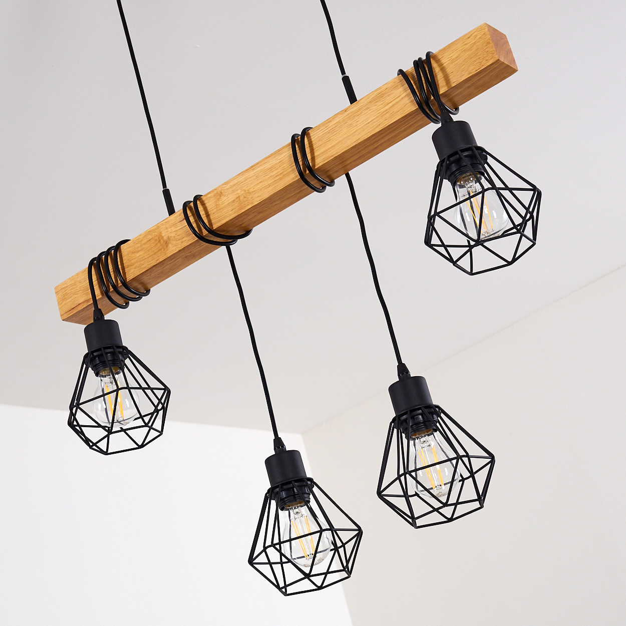 Holzbalken mit vier schwarzen Drahtlampenschirmen und Glühbirnen.