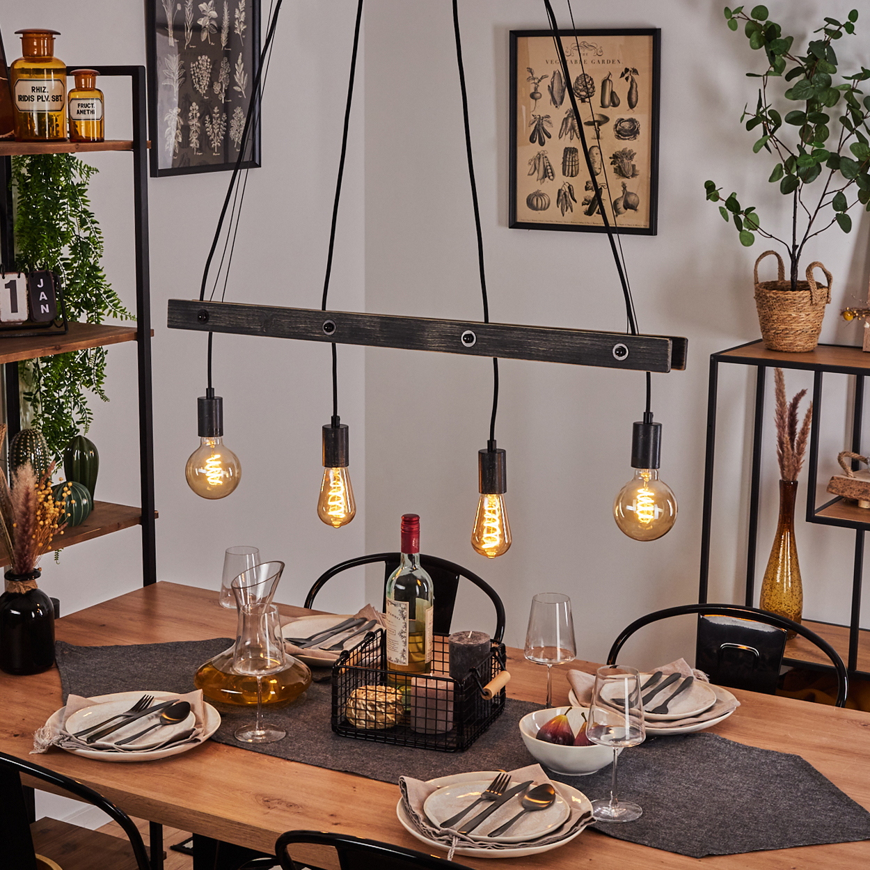 Holztisch mit gedeckter Tafel, Wein und Hängeleuchte.