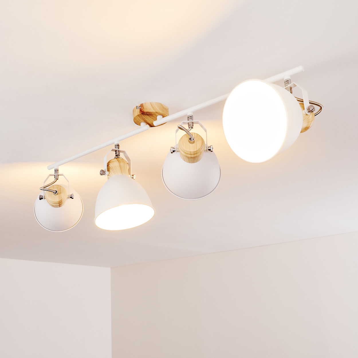 Weiße Deckenleuchte mit vier verstellbaren Spots und Holzdetails.