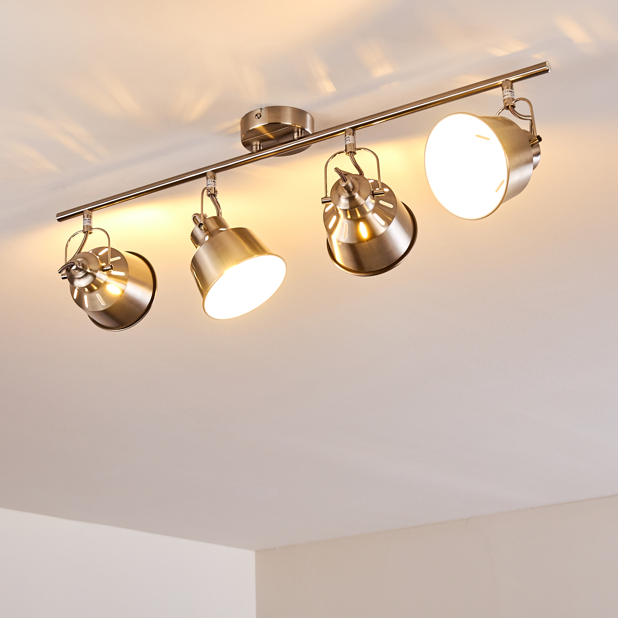 Deckenstrahler mit vier verstellbaren Metallspots an einer Stange.