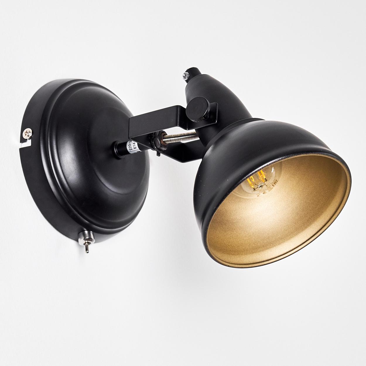 Eine schwarze Wandlampe mit verstellbarem Arm und goldener Innenseite.
