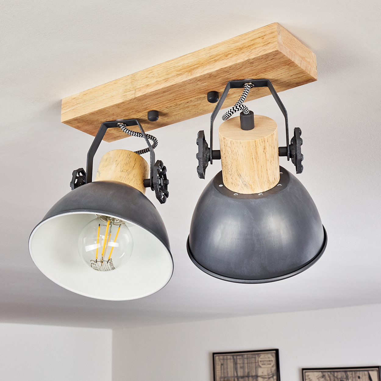 Zwei industrielle Deckenleuchten mit Holzbalken und Metallschirmen.