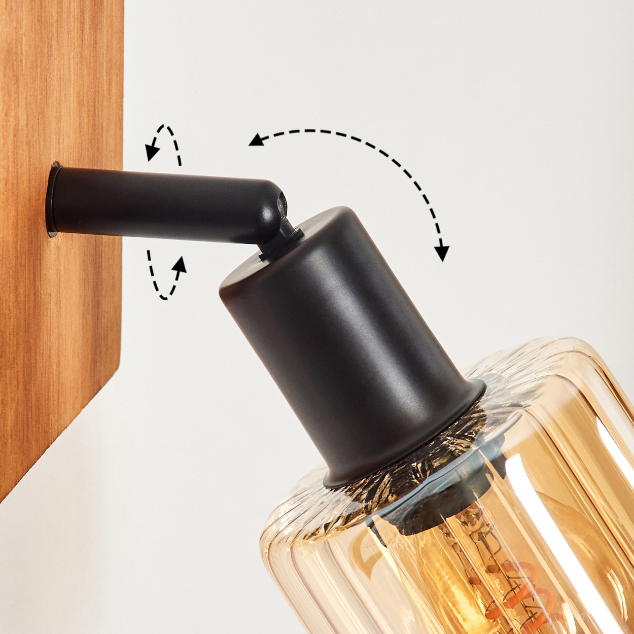 Schwarz verstellbare Wandleuchte mit bernsteinfarbenem Glas und Glühbirne.